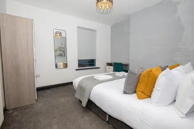 a bedroom with two beds with white and yellow pillows at Delamore Place Cozy Home 3BR near City in Liverpool