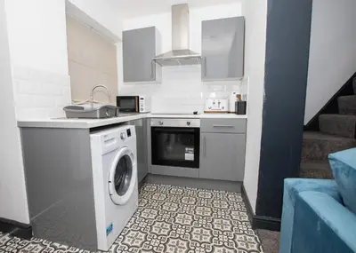 a kitchen with a washing machine and a sink at Delamore Place Cozy Home 3BR near City in Liverpool
