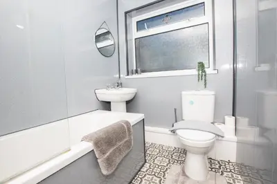 a white bathroom with a toilet and a sink at Delamore Place Cozy Home 3BR near City in Liverpool