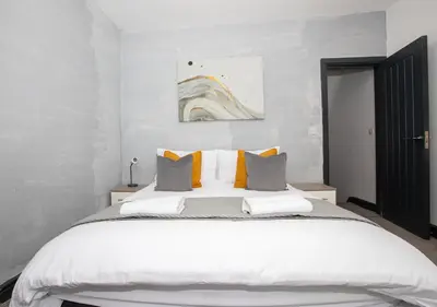 a bedroom with a large white bed with orange pillows at Delamore Place Cozy Home 3BR near City in Liverpool