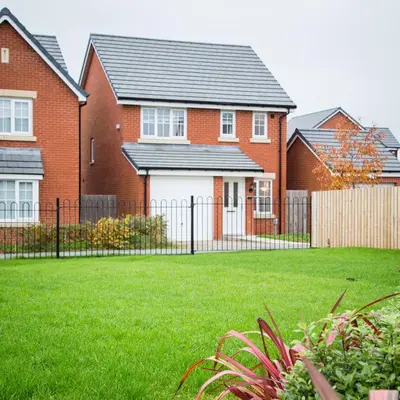 a house with a fence and a grass yard at Comfortable 3-bedroom Bolton home in Westhoughton