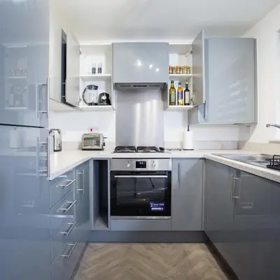 a kitchen with stainless steel appliances and white cabinets at Comfortable 3-bedroom Bolton home in Westhoughton