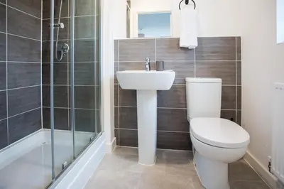 a bathroom with a toilet and a sink and a shower at Comfortable 3-bedroom Bolton home in Westhoughton