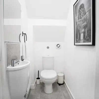 a white bathroom with a toilet and a sink at Comfortable 3-bedroom Bolton home in Westhoughton