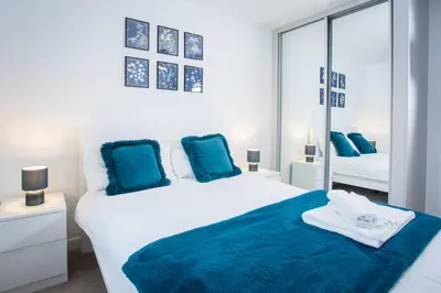 a bedroom with two beds with blue pillows at Comfortable 3-bedroom Bolton home in Westhoughton