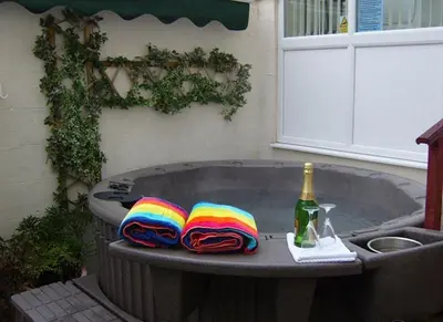 a hot tub with a bottle of wine and towels at Pride Lodge in Blackpool