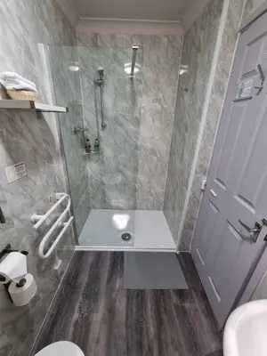 a bathroom with a shower and a toilet and a door at Pride Lodge in Blackpool