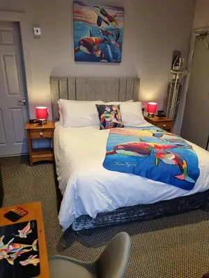 a bedroom with a bed with a superhero blanket on it at Pride Lodge in Blackpool