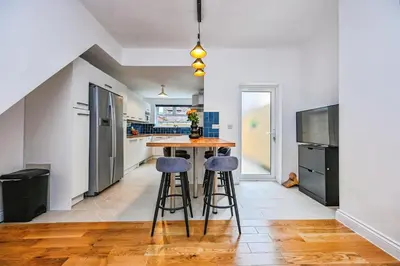 a kitchen with a table and two stools at 4 bed house Liverpool L7 in Liverpool