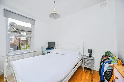 a white bedroom with a bed and a window at 4 bed house Liverpool L7 in Liverpool