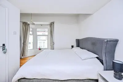 a bedroom with a large white bed and a window at 4 bed house Liverpool L7 in Liverpool