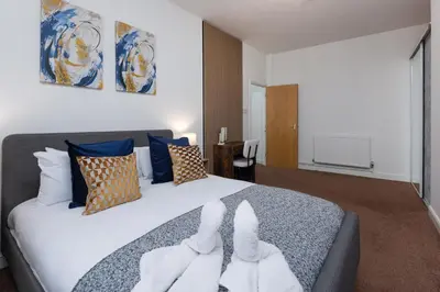 a bedroom with a large bed with two white towels at Harrington Chambers by Charming Apartments - Pool Table & Ping Pong in Liverpool