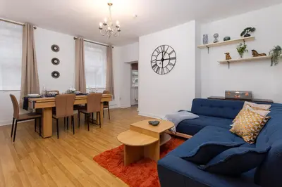 a living room with a blue couch and a table at Harrington Chambers by Charming Apartments - Pool Table & Ping Pong in Liverpool