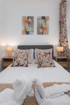 a bedroom with a white bed with two pillows at Harrington Chambers by Charming Apartments - Pool Table & Ping Pong in Liverpool