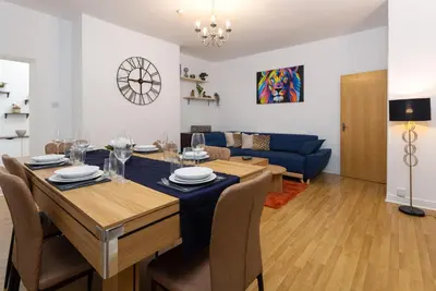 a dining room and living room with a table and chairs at Harrington Chambers by Charming Apartments - Pool Table & Ping Pong in Liverpool