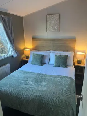 a bedroom with a large bed with two pillows at 2025 Willerby Ellerton Static Caravan in Morecambe
