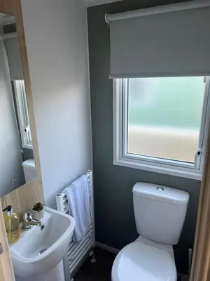 a bathroom with a toilet and a sink and a window at 2025 Willerby Ellerton Static Caravan in Morecambe