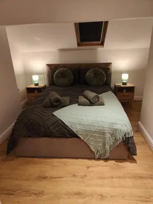 a bedroom with a large bed with two night stands at luxury Maisonette near beach in Morecambe