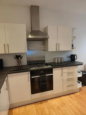 a kitchen with white cabinets and a stove top oven at luxury Maisonette near beach in Morecambe