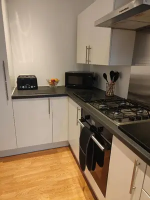 a kitchen with white cabinets and a stove top oven at luxury Maisonette near beach in Morecambe