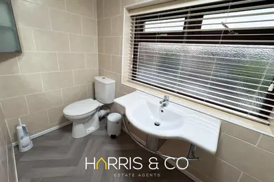 a bathroom with a toilet and a sink and a window at Sandringham & Spa Villa in Thornton