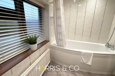 a bathroom with a tub and a window with a plant at Sandringham & Spa Villa in Thornton