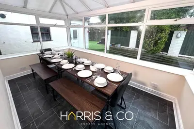 a dining room with a long table and chairs at Sandringham & Spa Villa in Thornton