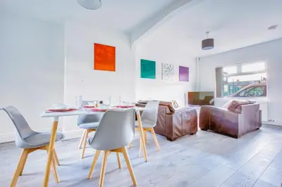 a living room with a table and chairs and a couch at Modern 3-Bed Home Sleeps 6 with Parking & Fast WiFi Perfect for Contractors & Long Stays in Saint Helens