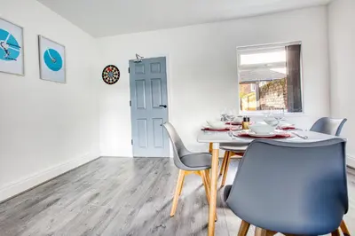 a dining room with a table and chairs at Modern 3-Bed Home Sleeps 6 with Parking & Fast WiFi Perfect for Contractors & Long Stays in Saint Helens
