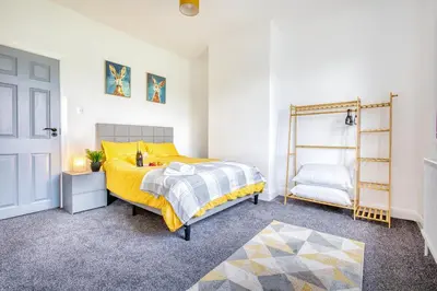 a bedroom with a bed and a yellow bedspread at Modern 3-Bed Home Sleeps 6 with Parking & Fast WiFi Perfect for Contractors & Long Stays in Saint Helens