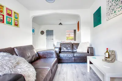 a living room with a leather couch and a table at Modern 3-Bed Home Sleeps 6 with Parking & Fast WiFi Perfect for Contractors & Long Stays in Saint Helens