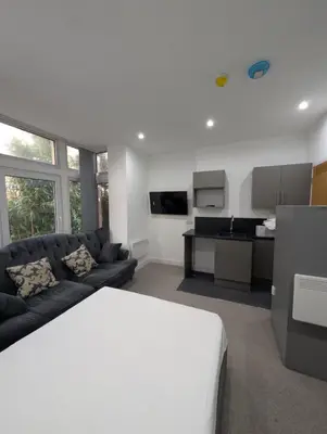 a living room with a couch and a kitchen at Park Lodge Preston in Preston