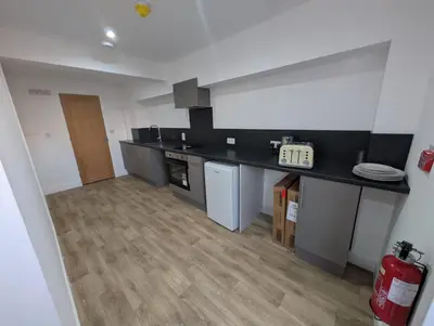 a kitchen with black counter tops and wooden floors at Park Lodge Preston in Preston