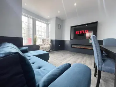 a living room with a couch and a tv at Serenity Wembley in Blackpool