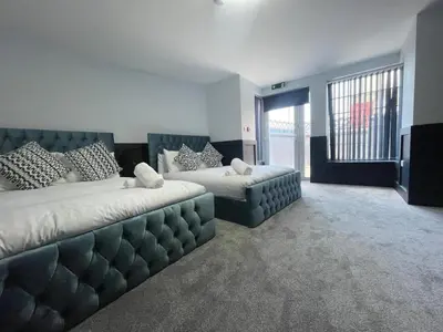 a large bedroom with two beds and a couch at Serenity Wembley in Blackpool