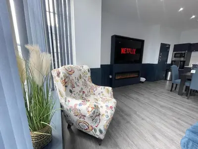a living room with a chair and a tv at Serenity Wembley in Blackpool