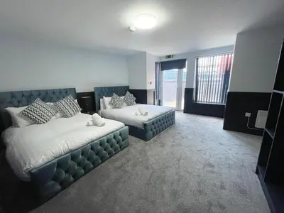 a bedroom with two beds and a couch and a window at Serenity Wembley in Blackpool