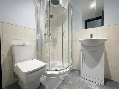 a bathroom with a shower and a toilet and a sink at Serenity Wembley in Blackpool