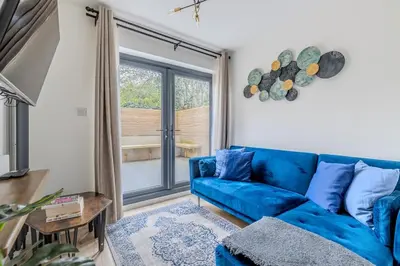 a blue couch in a living room with a window at Chic 1BHK in West London in Lytham St Annes