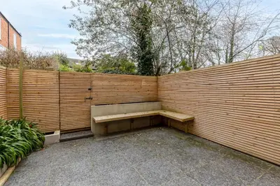 a wooden fence with a bench in front of it at Chic 1BHK in West London in Lytham St Annes