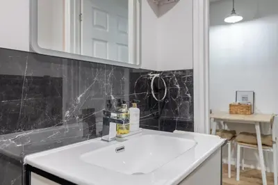 a bathroom with a white sink and a mirror at Chic 1BHK in West London in Lytham St Annes