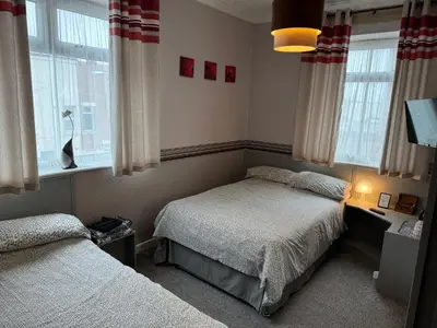 a bedroom with two beds and a window at West Vale Villa in Blackpool