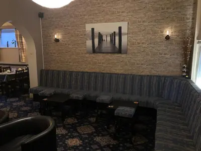 a bar with a couch and a brick wall at West Vale Villa in Blackpool