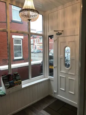 a room with windows and a chandelier and a door at West Vale Villa in Blackpool