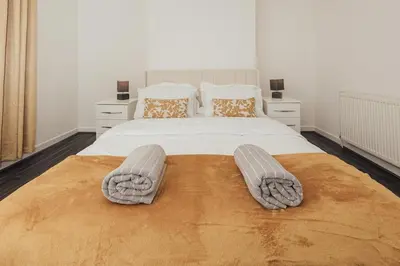 a bedroom with a large bed with two slippers on it at Stylish 3 Bed Home with 4 beds- 5 Min walk From Anfield Stadium in Liverpool