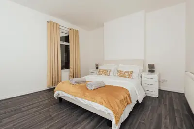 a white bedroom with a bed and a window at Stylish 3 Bed Home with 4 beds- 5 Min walk From Anfield Stadium in Liverpool