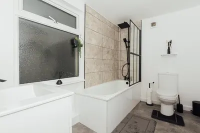 a white bathroom with a tub and a toilet at Stylish 3 Bed Home with 4 beds- 5 Min walk From Anfield Stadium in Liverpool