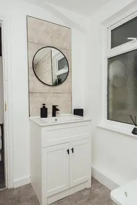 a white bathroom with a sink and a mirror at Stylish 3 Bed Home with 4 beds- 5 Min walk From Anfield Stadium in Liverpool
