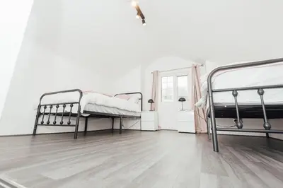 a bedroom with two beds and a wooden floor at Stylish 3 Bed Home with 4 beds- 5 Min walk From Anfield Stadium in Liverpool