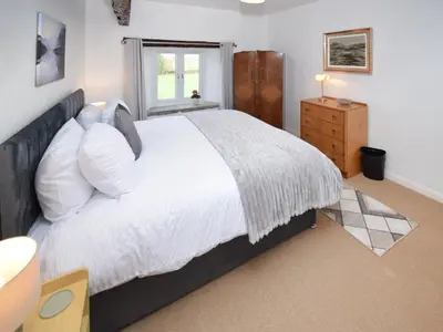 a bedroom with a large white bed with a window at The Old Farm House in Beetham